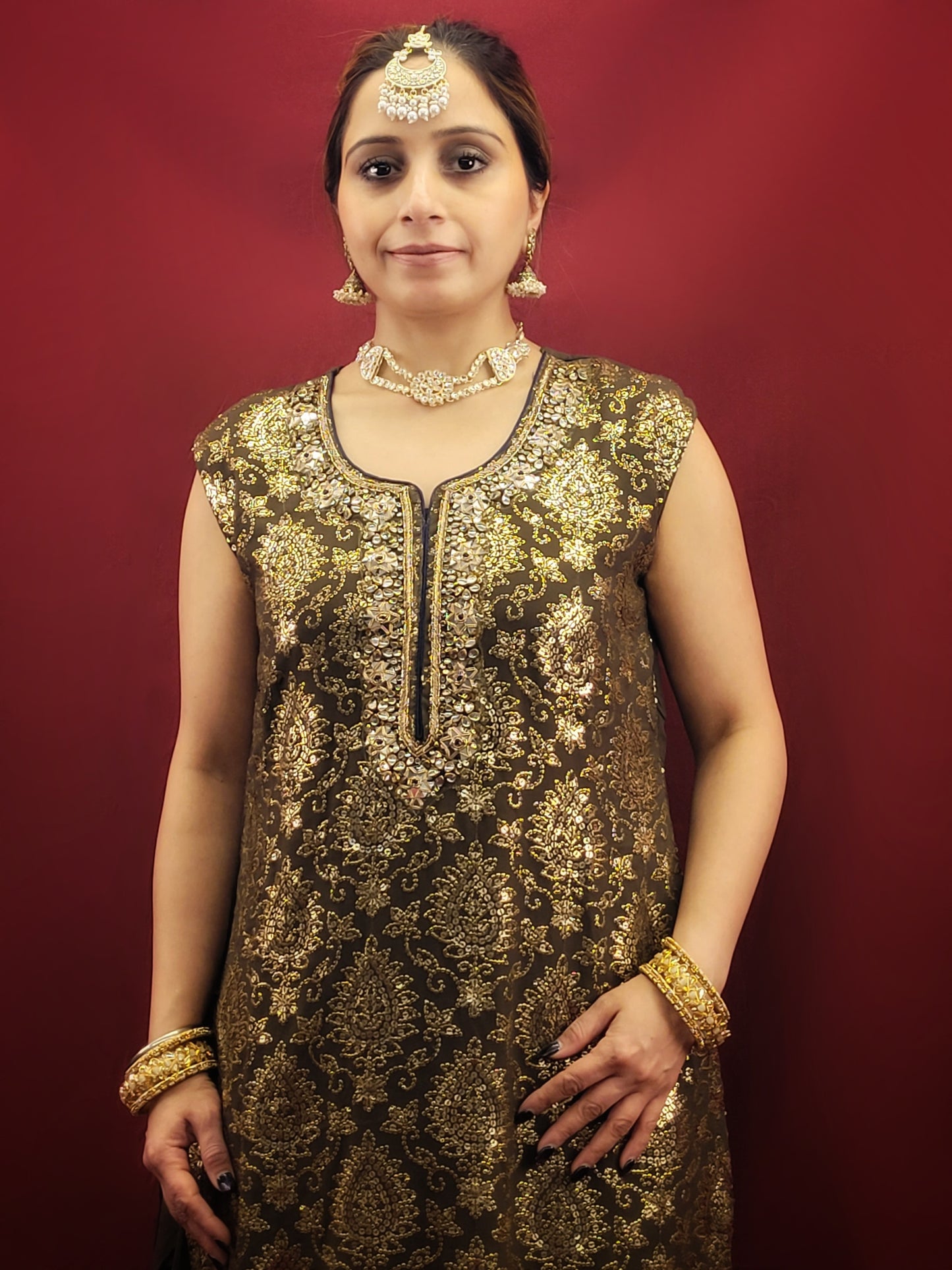 The Mehendi Green Sharara Kameez set, paired with exclusive banarasi dupatta, and adorned with sequins, kundan and beads, is a georgette masterpiece for wedding and party ethnic wear.