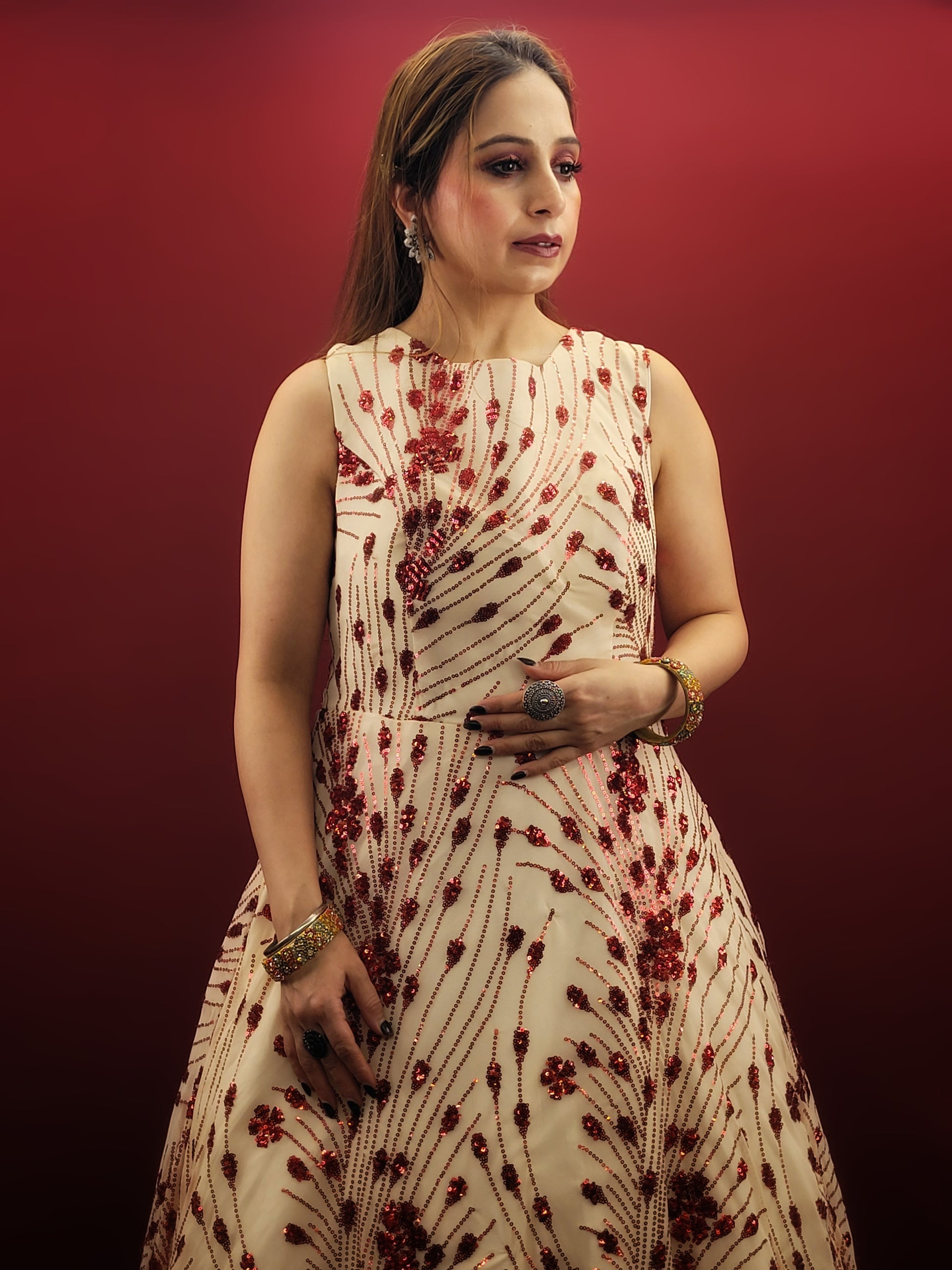 Step into the spotlight with an imported cream bridal gown, its red sequins catching the light with every step, ideal for your wedding, or as a dazzling choice for engagement and party wear.