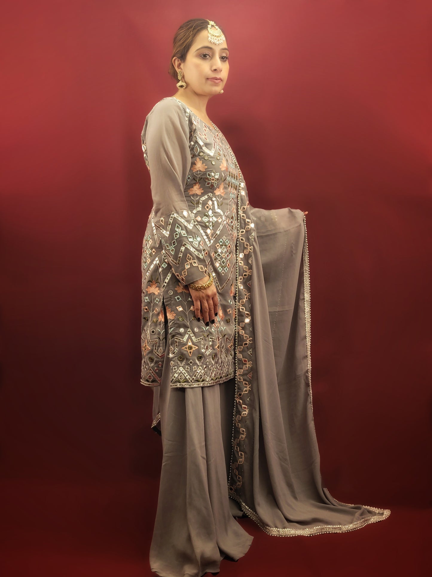 Embrace elegance with a light grey Indowestern Sharara set, meticulously crafted with foil and thread on georgette making it a sophisticated choice for any arty wear collection.