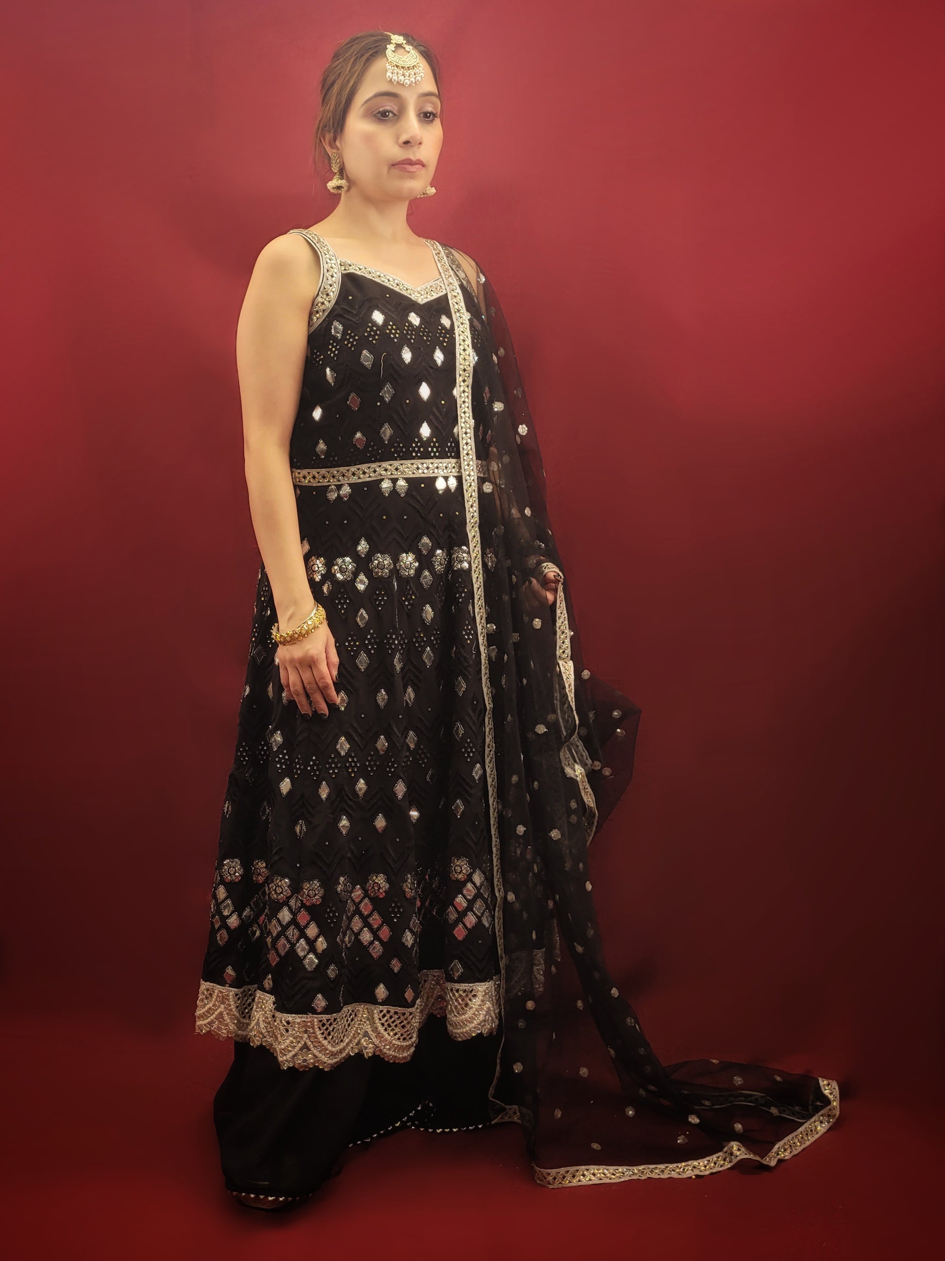 The black georgette sharara with an Anarkali, featuring foil mirror work, is a versatile ensemble that's ideal for a variety of occasions. It is perfect for weddings, festive celebrations, cocktail parties, and any event where Indian ethnic fusion is appreciated. It's elegance makes it a standout choice for making a sophisticated statement. 