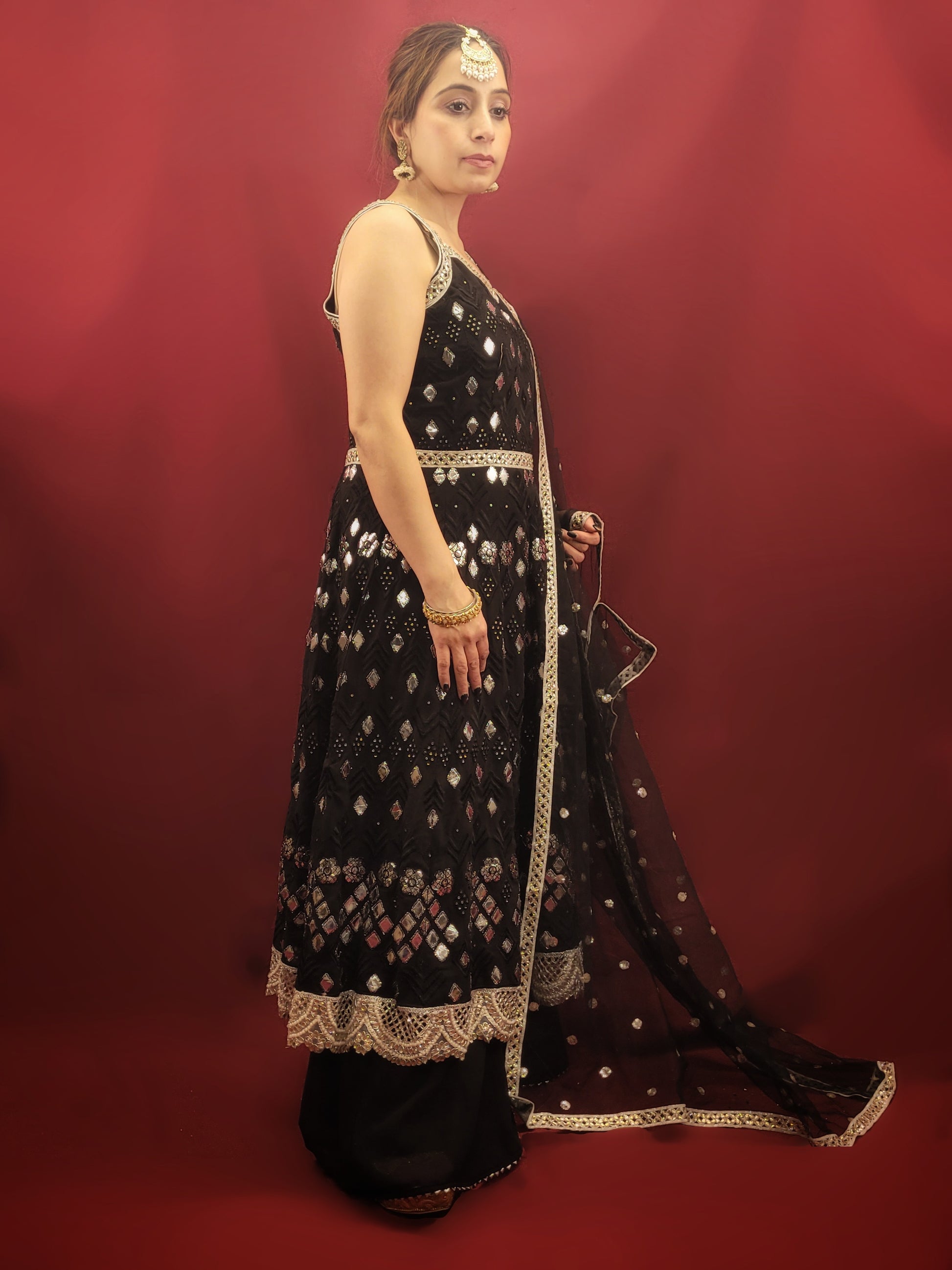 The black georgette sharara with an Anarkali, featuring foil mirror work, is a versatile ensemble that's ideal for a variety of occasions. It is perfect for weddings, festive celebrations, cocktail parties, and any event where Indian ethnic fusion is appreciated. It's elegance makes it a standout choice for making a sophisticated statement. 