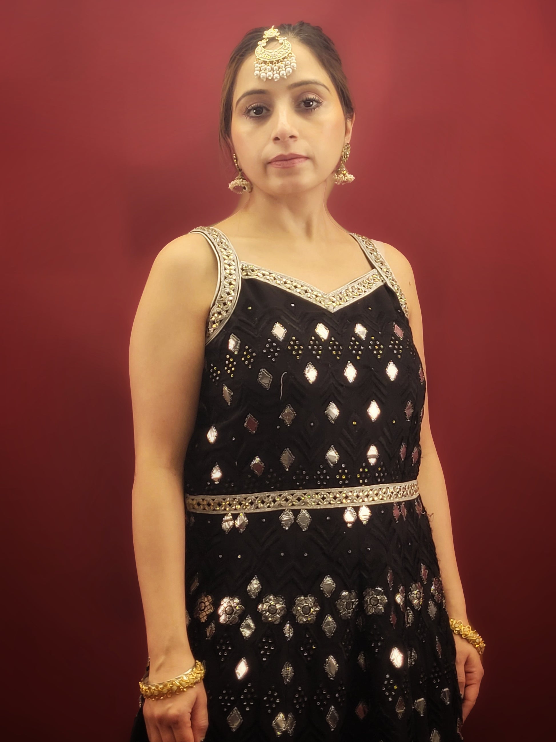 The black georgette sharara with an Anarkali, featuring foil mirror work, is a versatile ensemble that's ideal for a variety of occasions. It is perfect for weddings, festive celebrations, cocktail parties, and any event where Indian ethnic fusion is appreciated. It's elegance makes it a standout choice for making a sophisticated statement. 
