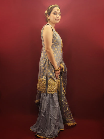 Upgrade your wardrobe with this luxurious Sharara Kameez Suit. The Light Grey Sharara Kameez showcases Banarasi and Chinnon fabrics, embellished with intricate Zari and Zarkan work. The heavy look dupatta adds to its grandeur, perfect for party wear or weddings. Elevate your style with this exclusive and sophisticated ensemble.