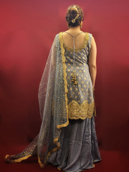 Upgrade your wardrobe with this luxurious Sharara Kameez Suit. The Light Grey Sharara Kameez showcases Banarasi and Chinnon fabrics, embellished with intricate Zari and Zarkan work. The heavy look dupatta adds to its grandeur, perfect for party wear or weddings. Elevate your style with this exclusive and sophisticated ensemble.