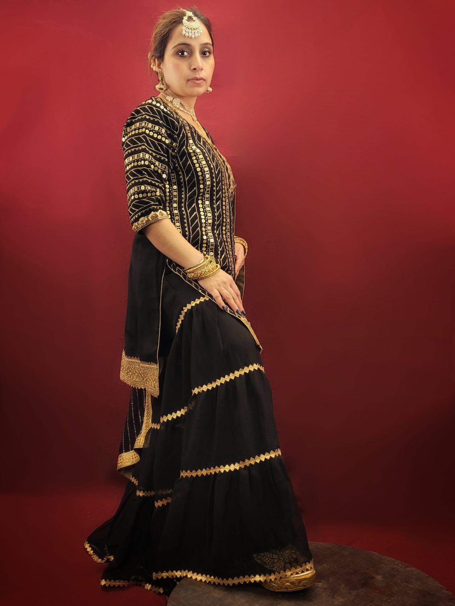 This black kameez and sharara set with sequins is perfect for a variety of occasions, from festive celebrations, to wedding events, making it a versatile choice for those seeking a blend of traditional and indo-western ethnic wear. It is ideal for adding a touch of glamour to any special occasion.