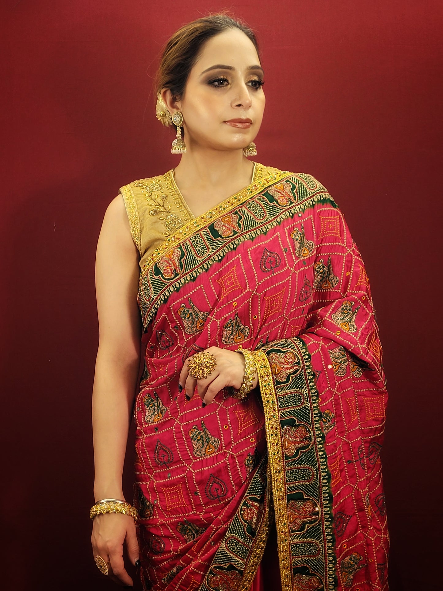 Beautiful Rani Pink Gajji Silk Bridal Saree with a gorgeous green pallu that would be perfect for the upcoming wedding season. The saree is embellished with intricate cutdana, zari, and threadwork that truly make it stand out. The silk material gives it a luxurious feel that's sure to make you feel like royalty on your big day. 