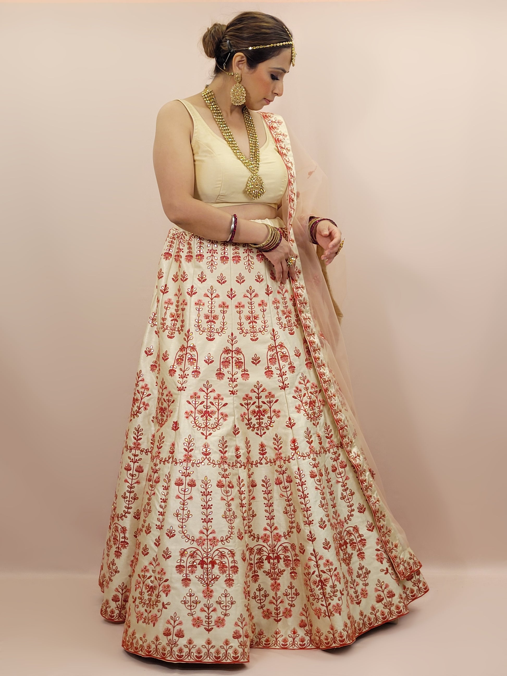 Immerse yourself in the elegance of Indian tradition with this exquisite Cream color silk unstitched lehenga, inspired by the renowned designer Anita Dongre. This lehenga is a true masterpiece, featuring intricate resham embroidery and delicate beads work that beautifully adorns the luxurious silk fabric, creating a captivating and sophisticated look.
