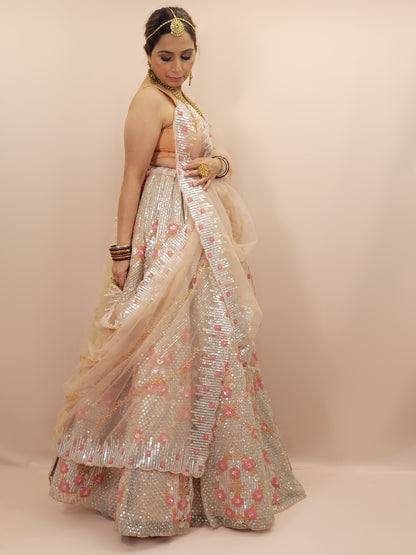 Elevate your ethnic wardrobe with this stunning ivory-colored net unstitched lehenga, a perfect blend of traditional craftsmanship and contemporary elegance. This lehenga is intricately adorned with shimmering water sequins and delicate glass beads work, creating a mesmerizing effect that catches the light with every movement.