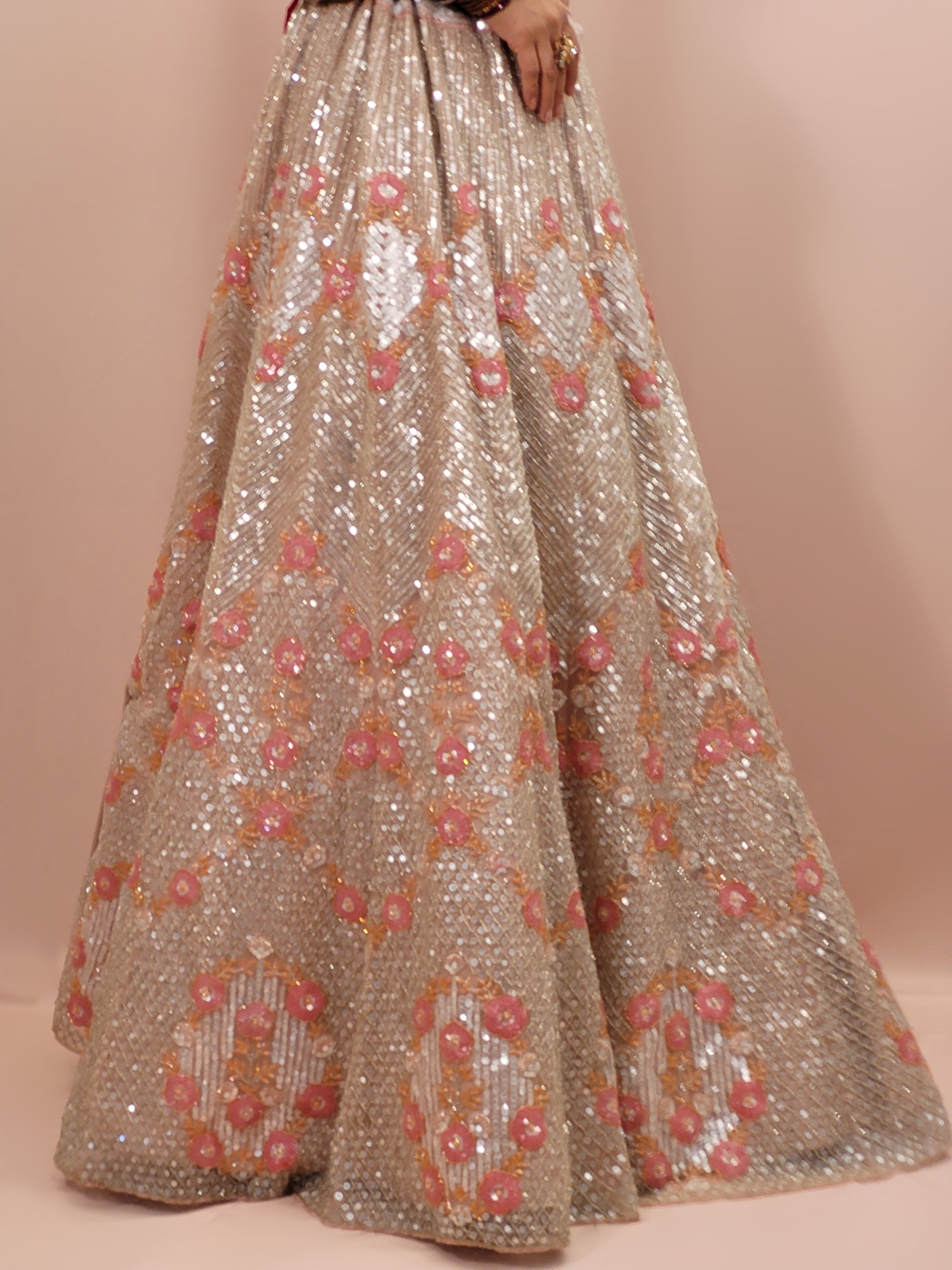 Elevate your ethnic wardrobe with this stunning ivory-colored net unstitched lehenga, a perfect blend of traditional craftsmanship and contemporary elegance. This lehenga is intricately adorned with shimmering water sequins and delicate glass beads work, creating a mesmerizing effect that catches the light with every movement.