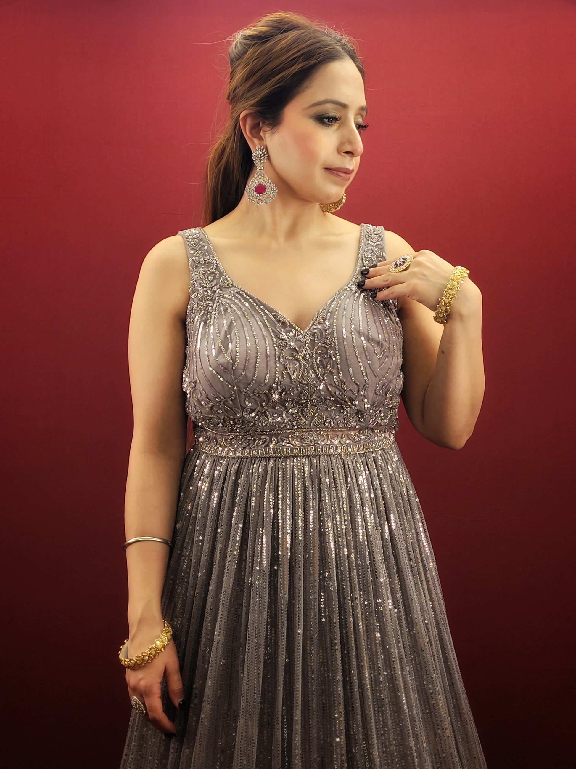 The perfect gown to wear to your upcoming engagement, cocktail party, or wedding reception. Allow us to introduce you to this stunning silver grey gown made from imported fabric and adorned with intricate cutdana beads and sequins work.