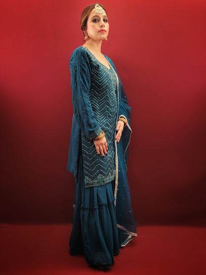 Prussian blue georgette kameez sharara set is the perfect choice for anyone looking for a stylish and elegant outfit for their next party or wedding event. The intricate cutdana, beads and zarkan work on the kameez and sleeves add a touch of glamour and sophistication to the overall design.