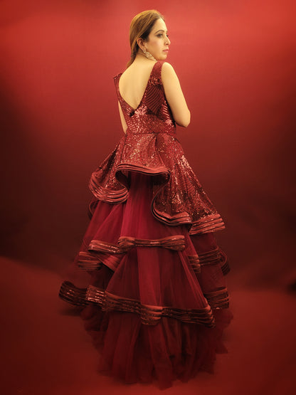 Make a captivating entrance at your engagement, reception, or any grand party with this stunning Maroon Net Ball Gown. Layers of delicate net cascade down to create a voluminous skirt, fit for a fairytale. Shimmering sequins adorn the gown, catching the light and adding a touch of glamour.