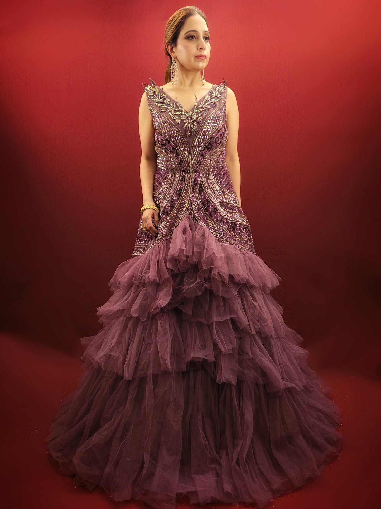 Embrace a captivating silhouette and exquisite detailing with this Onion Net Mermaid Gown. Crafted from luxurious onion net, this gown drapes beautifully, hugging your curves and flaring out dramatically at the knee to create a stunning mermaid silhouette. The true showstopper, however, is the handcrafted embellishment on the front.