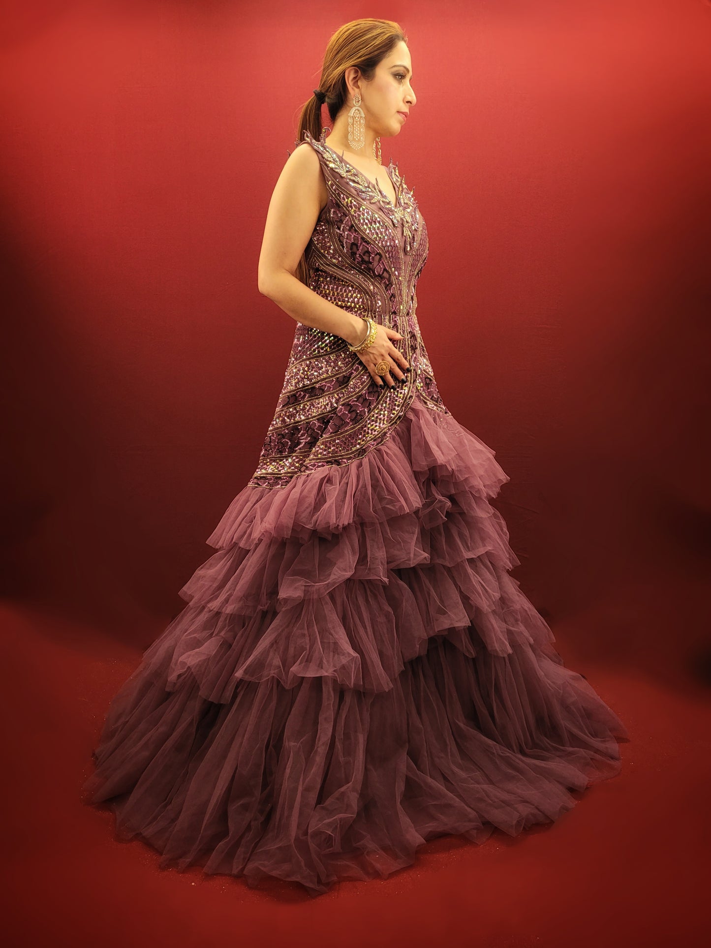 Embrace a captivating silhouette and exquisite detailing with this Onion Net Mermaid Gown. Crafted from luxurious onion net, this gown drapes beautifully, hugging your curves and flaring out dramatically at the knee to create a stunning mermaid silhouette. The true showstopper, however, is the handcrafted embellishment on the front.