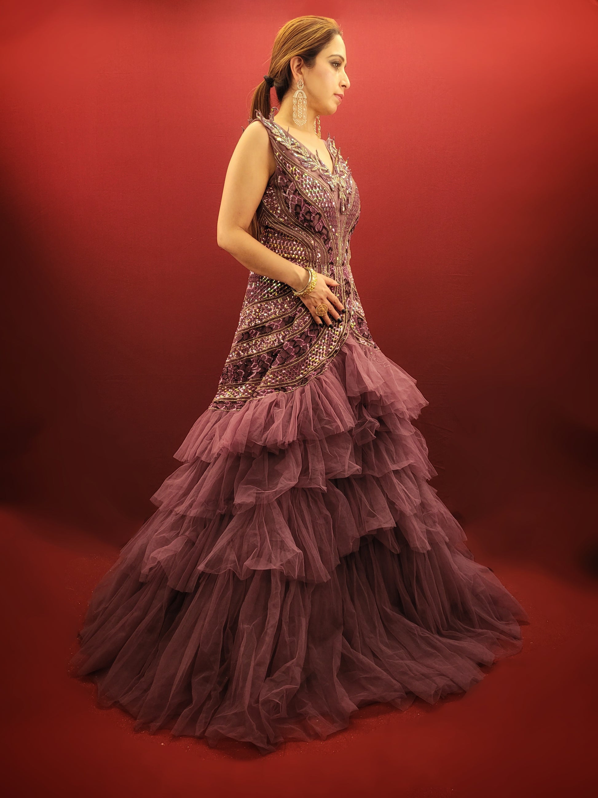 Embrace a captivating silhouette and exquisite detailing with this Onion Net Mermaid Gown. Crafted from luxurious onion net, this gown drapes beautifully, hugging your curves and flaring out dramatically at the knee to create a stunning mermaid silhouette. The true showstopper, however, is the handcrafted embellishment on the front.