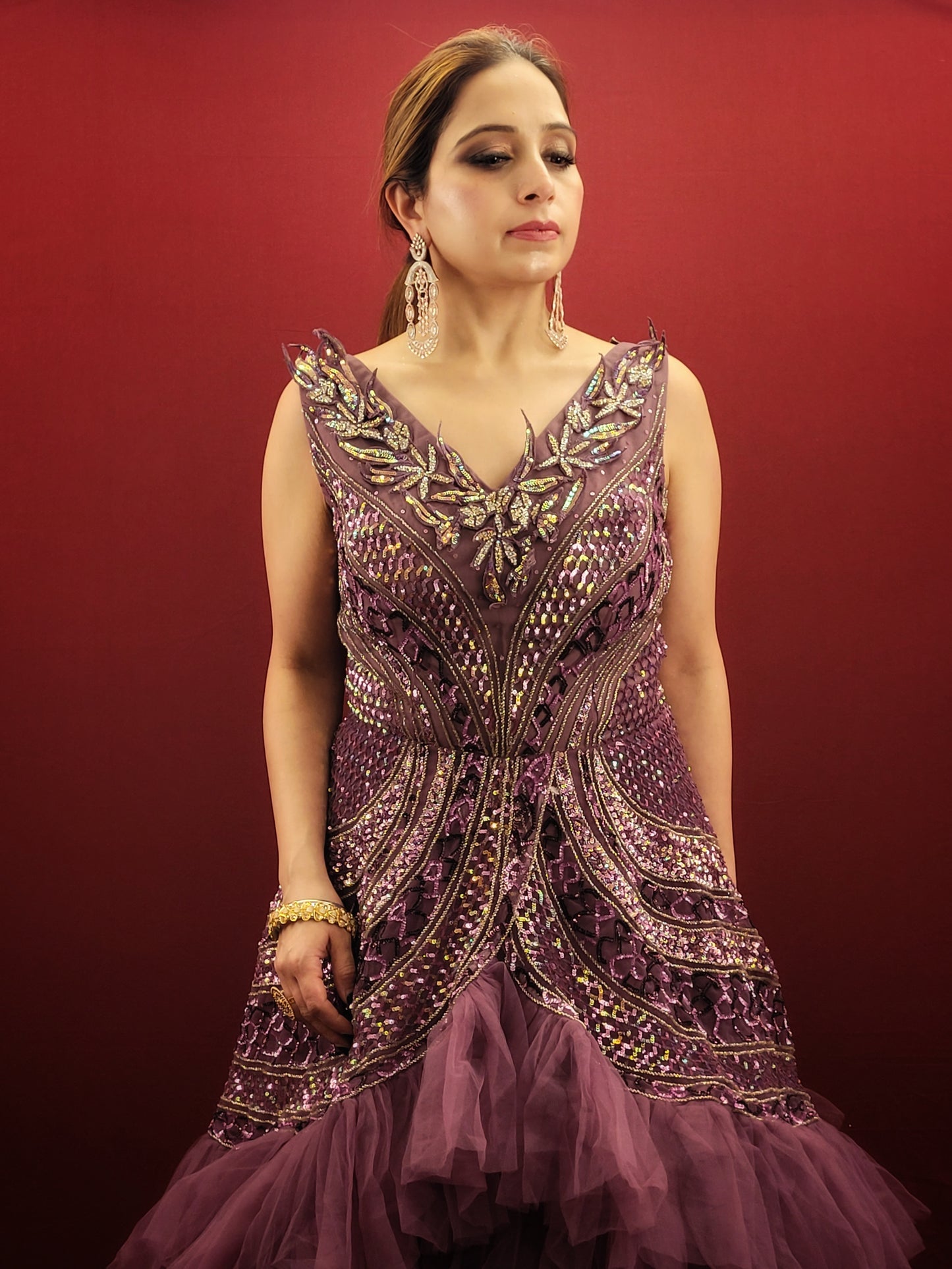 Embrace a captivating silhouette and exquisite detailing with this Onion Net Mermaid Gown. Crafted from luxurious onion net, this gown drapes beautifully, hugging your curves and flaring out dramatically at the knee to create a stunning mermaid silhouette. The true showstopper, however, is the handcrafted embellishment on the front.