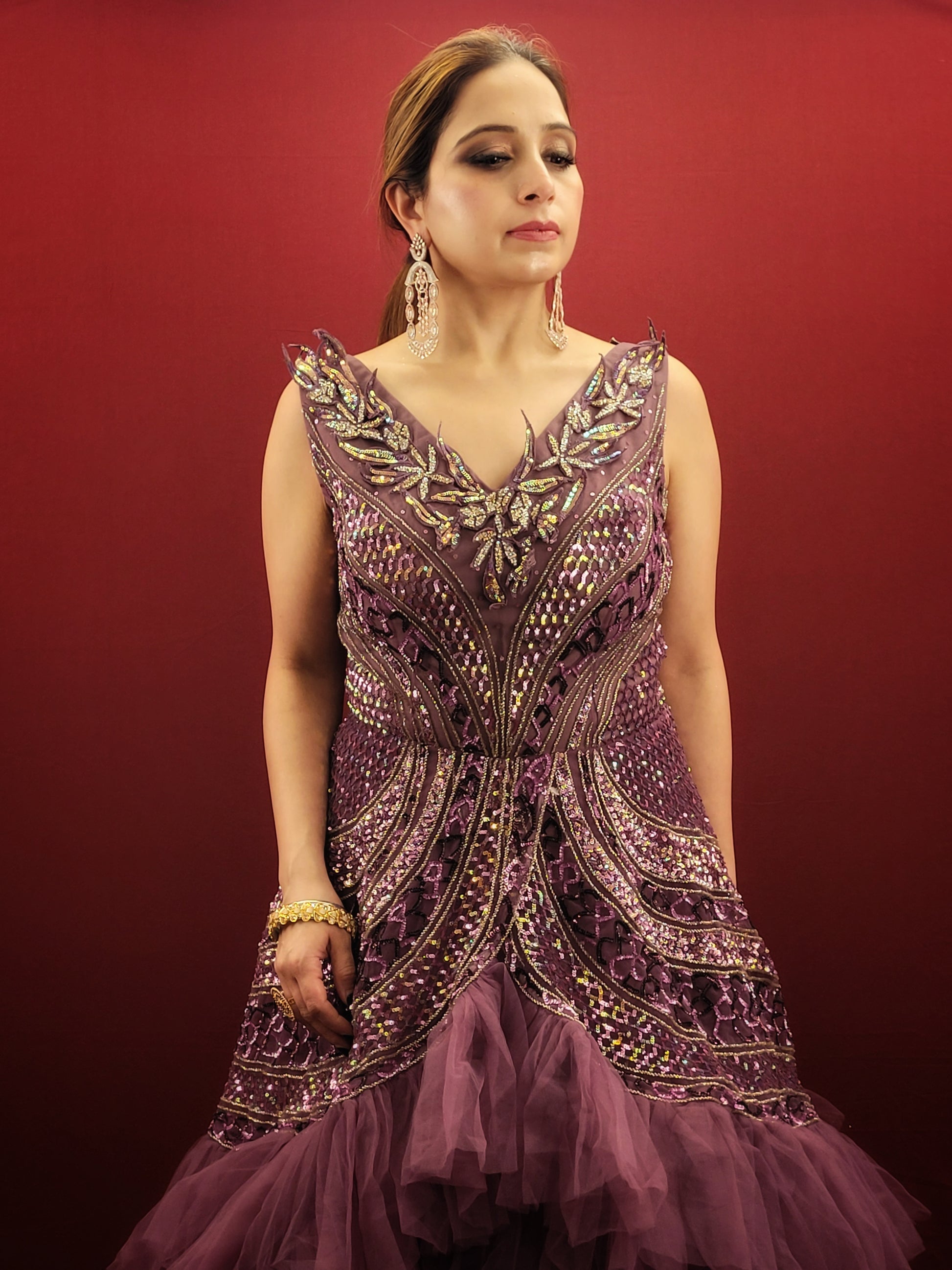 Embrace a captivating silhouette and exquisite detailing with this Onion Net Mermaid Gown. Crafted from luxurious onion net, this gown drapes beautifully, hugging your curves and flaring out dramatically at the knee to create a stunning mermaid silhouette. The true showstopper, however, is the handcrafted embellishment on the front.