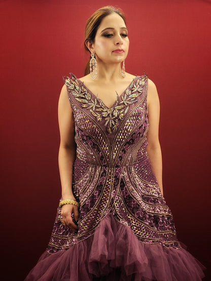 Embrace a captivating silhouette and exquisite detailing with this Onion Net Mermaid Gown. Crafted from luxurious onion net, this gown drapes beautifully, hugging your curves and flaring out dramatically at the knee to create a stunning mermaid silhouette. The true showstopper, however, is the handcrafted embellishment on the front.