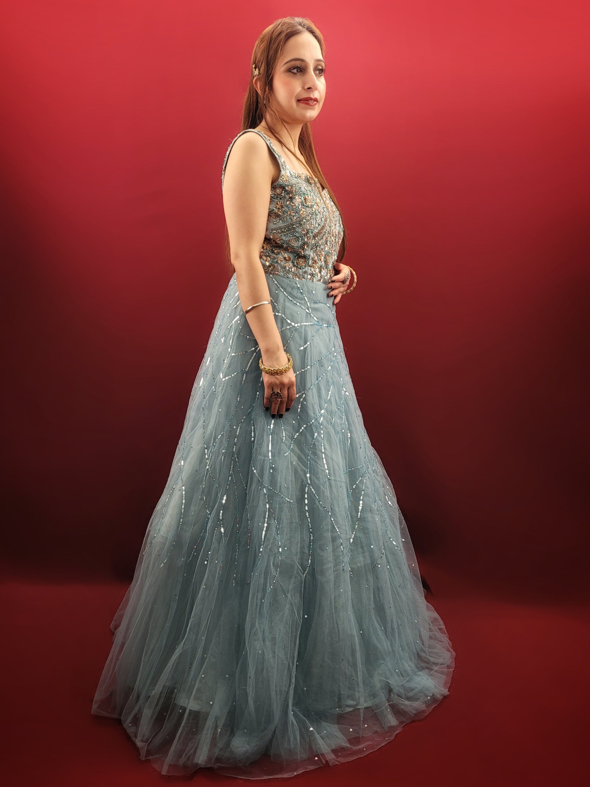 This mesmerizing net gown is a dream come true for any engagement or party. The fabric drapes beautifully, accentuated by a stunning half-baked cyan blue that flatters all skin tones. Intricate sequin and beadwork adds a touch of glamour, making this gown perfect for a night to remember.