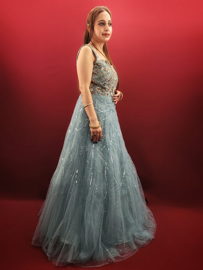 This mesmerizing net gown is a dream come true for any engagement or party. The fabric drapes beautifully, accentuated by a stunning half-baked cyan blue that flatters all skin tones. Intricate sequin and beadwork adds a touch of glamour, making this gown perfect for a night to remember.