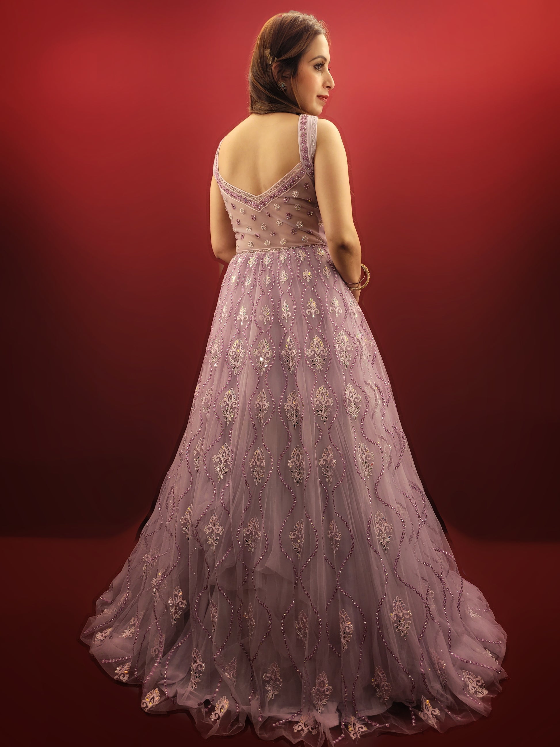 Be the star of your own fairytale with this mesmerizing Lavender Net Gown. Crafted from layers of light-as-air net, this gown drapes effortlessly, creating a silhouette that is both romantic and undeniably glamorous. Prepare to be swept away by the exquisite embellishments adorning this captivating piece.