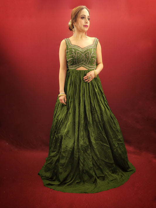 Make a lasting impression in this captivating mehendi green chinnon gown, perfect for your own engagement or reception, or as a stunning bridesmaid dress for your sister's or friend's wedding. The intricate glass bead handwork on the choli adds a touch of elegance and shimmer, while the crushed flared lower portion creates a gracefully voluminous silhouette.