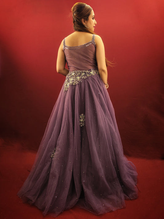 Embrace a look that's both romantic and unforgettable in this opera mauve net gown. The luxurious net fabric cascades down your figure, creating a silhouette that's both soft and ethereal. The true star of the show, however, is the 3D sculpted organza bodice.