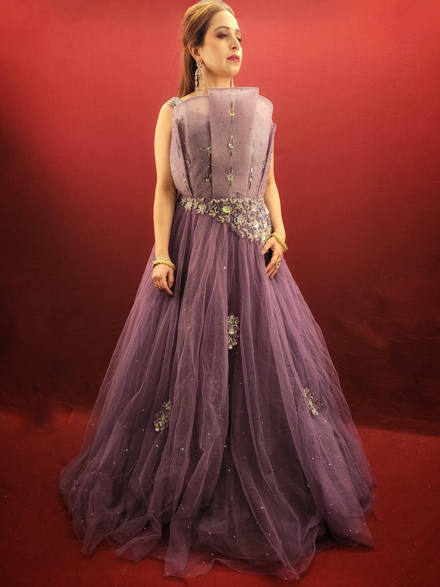 Embrace a look that's both romantic and unforgettable in this opera mauve net gown. The luxurious net fabric cascades down your figure, creating a silhouette that's both soft and ethereal. The true star of the show, however, is the 3D sculpted organza bodice.