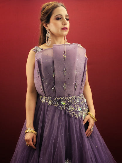 Embrace a look that's both romantic and unforgettable in this opera mauve net gown. The luxurious net fabric cascades down your figure, creating a silhouette that's both soft and ethereal. The true star of the show, however, is the 3D sculpted organza bodice.