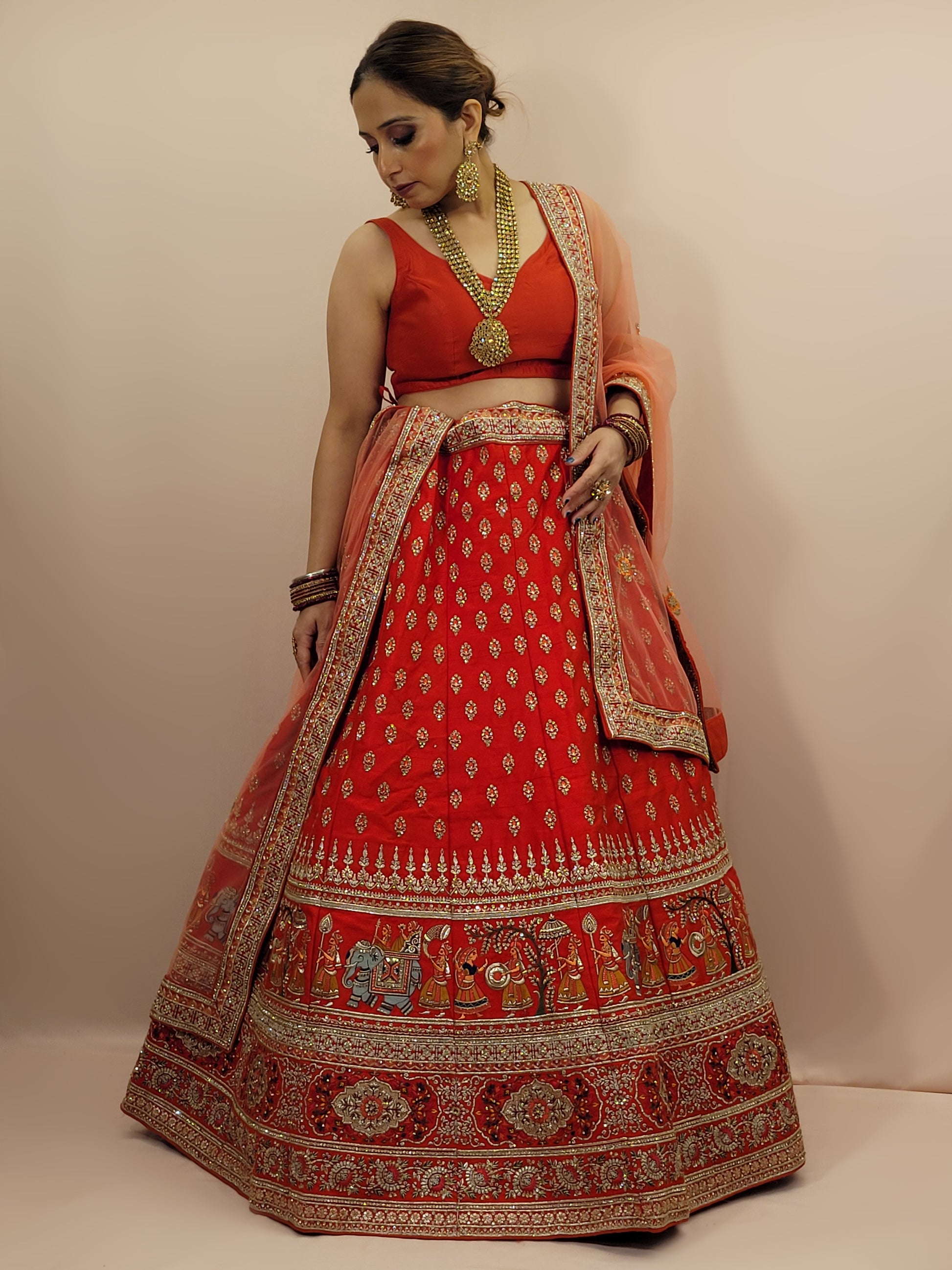 Lehenga:&nbsp;Crafted from luxurious silk, this red bridal lehenga is adorned with intricate multicolor embroidery using Resham, Zari, and Zarkan techniques. The heavy embroidery showcases the rich heritage of Indian craftsmanship, making it a perfect choice for brides.
Blouse:&nbsp;The set comes with a heavily embroidered unstitched blouse, allowing you to tailor it to your perfect fit. Please note, the blouse worn by the model is for reference purposes only.