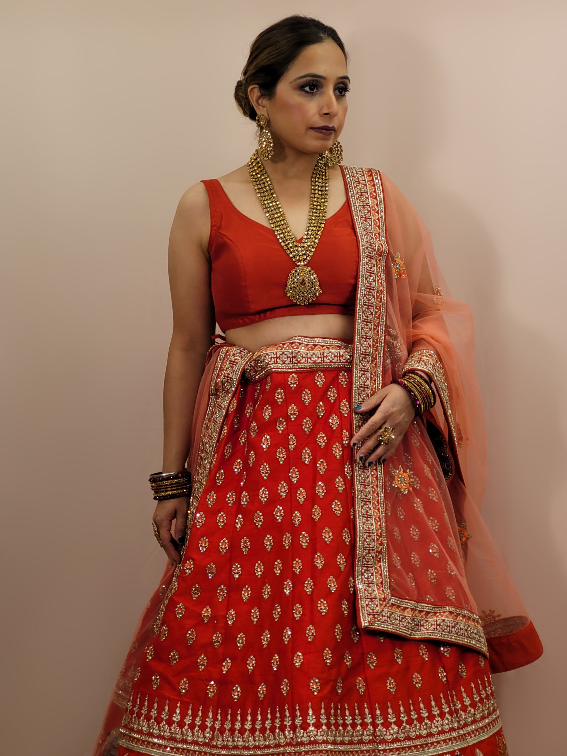 Lehenga:&nbsp;Crafted from luxurious silk, this red bridal lehenga is adorned with intricate multicolor embroidery using Resham, Zari, and Zarkan techniques. The heavy embroidery showcases the rich heritage of Indian craftsmanship, making it a perfect choice for brides.
Blouse:&nbsp;The set comes with a heavily embroidered unstitched blouse, allowing you to tailor it to your perfect fit. Please note, the blouse worn by the model is for reference purposes only.