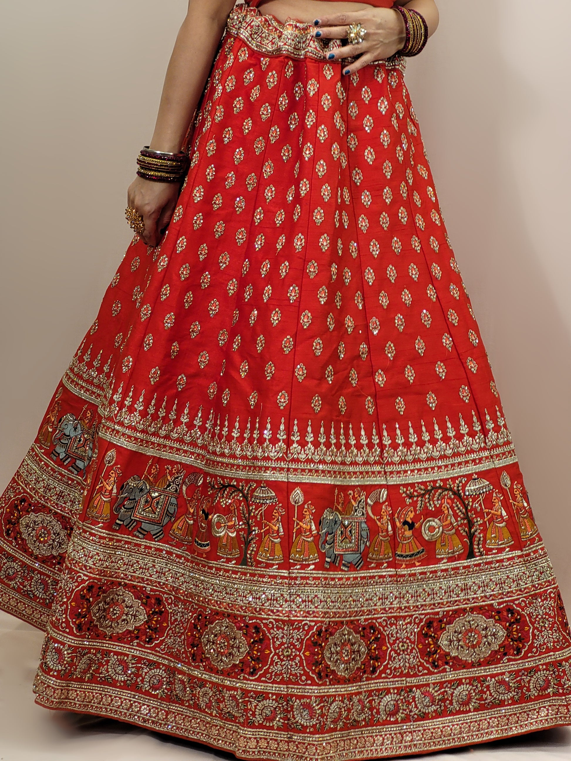 Lehenga:&nbsp;Crafted from luxurious silk, this red bridal lehenga is adorned with intricate multicolor embroidery using Resham, Zari, and Zarkan techniques. The heavy embroidery showcases the rich heritage of Indian craftsmanship, making it a perfect choice for brides.
Blouse:&nbsp;The set comes with a heavily embroidered unstitched blouse, allowing you to tailor it to your perfect fit. Please note, the blouse worn by the model is for reference purposes only.