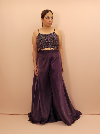 Elevate your festive wardrobe with our Purple Shimmer Pallazo Top Indowestern Fusion Set - a perfect blend of tradition and modernity. This stunning ensemble features a sleeveless cropped blouse adorned with exquisite beadwork and sparkling sequins that catch the light beautifully. Paired with a high-waisted, flowing Pallazo in luxurious Purple Jimmy Choo fabric, this outfit promises an elegant silhouette and timeless grace. Ideal for weddings, celebrations, or any special event